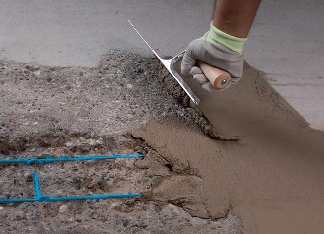 A concrete repair material being applied with a trowel